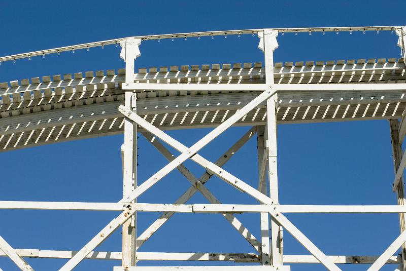 Free Stock Photo: Wooden support frame of a rollercoaster ride with empty track viewed from below against a blue sky