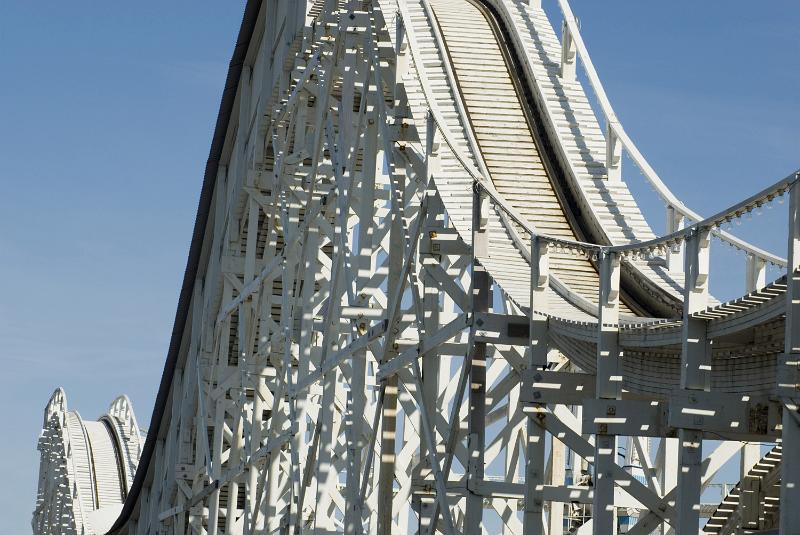 Free Stock Photo: An empty roller coast track and hills on a sunny day with a clear, blue sky.