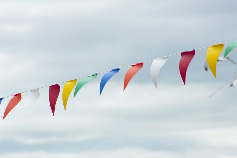 Free Stock Photo: String of colorful triangular bunting flying against a cloudy grey sky with copy space conceptual of celebration, festival or party