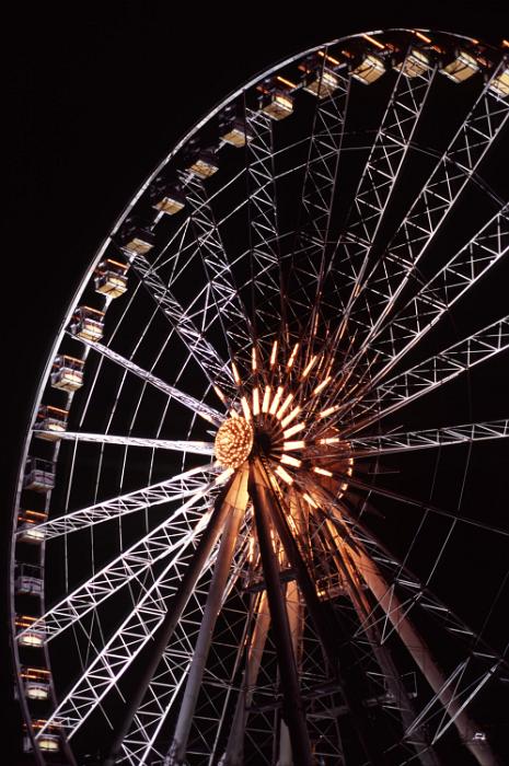 Free Stock Photo: Close up on a giant ferris wheel with gondolas to ride at an amusement park of fairground illuminated at night