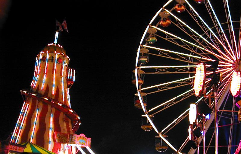 Free Stock Photo: A giant ferris wheel and amusement park at night, lit by neon lights.