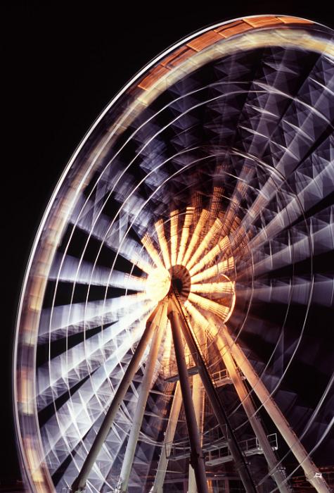 Free Stock Photo: Spinning ferris wheel with motion blur illuminated at night for a thrilling ride at an amusement park of fairground