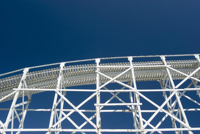 Free Stock Photo: Low angle view of the track of a Big Dipper roller coaster looking up at the crest of a hill against a blue sky