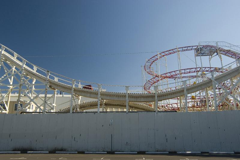 Free Stock Photo: An empty roller coaster track on a sunny day with a clear, blue sky.