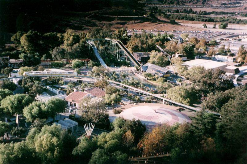 Free Stock Photo: Aerial view of the layout of an amusement park or theme park with buildings and infrastructure nestled amongst green trees in countryside