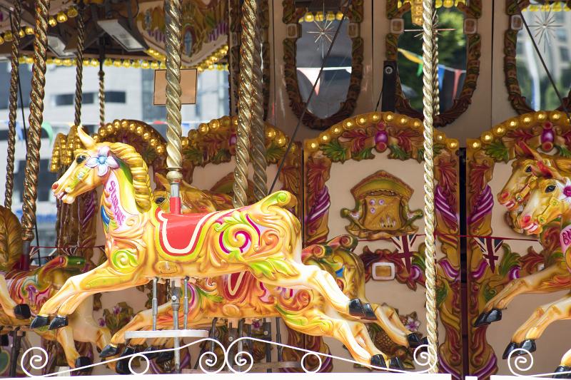 Free Stock Photo: A close up of horses on a traditional merry-go-round carousel at an amusement park.