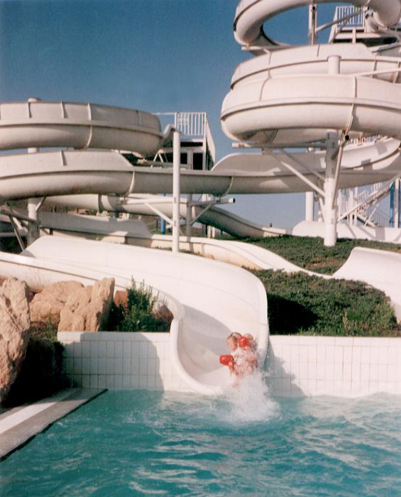 Free Stock Photo: Person riding the slides at a water park entering the water of the pool below with a splash