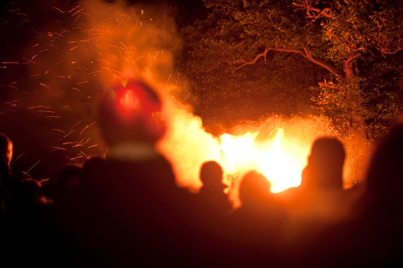 Free Stock Photo: Spectators watching a blazing bonfire with orange flames shooting into the air on Bonfire Night or Guy Fawkes