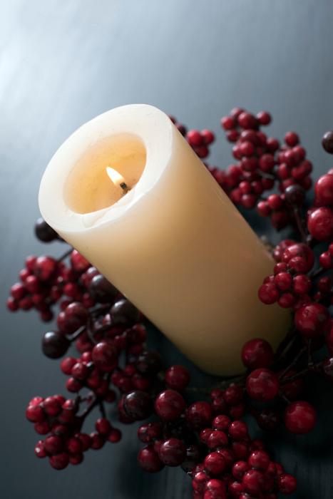Free Stock Photo: a large chruch candle, lit and surrounded by a wreath of red berries