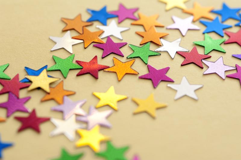Free Stock Photo: Colorful stars background with numerous, multicolored stars scattered across a festive yellow background viewed low angle with shallow dof