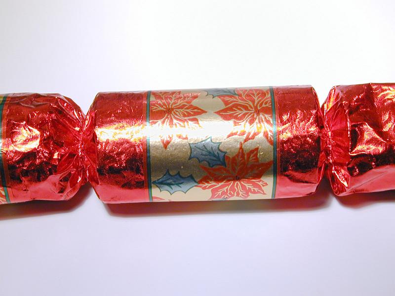 Free Stock Photo: Colorful red Christmas cracker for a festive table decoration to be pulled to release the surprise hidden inside