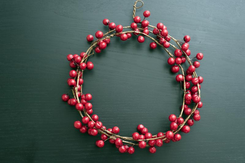 Free Stock Photo: Red cranberry circular berry wreath for Christmas over a drak background with copy space for a seasonal greeting