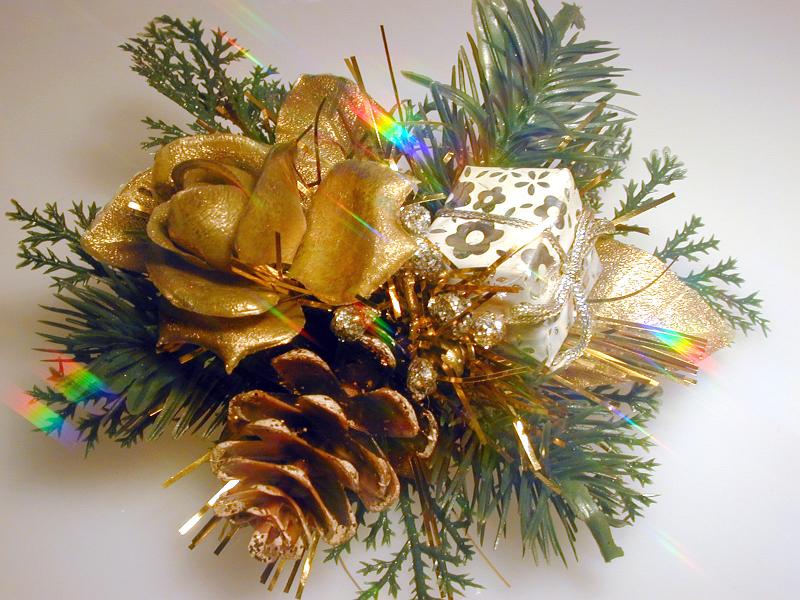 Free Stock Photo: Gold themed festive bundle with a rose, pine cone and small Christmas gift in green foliage, close up view