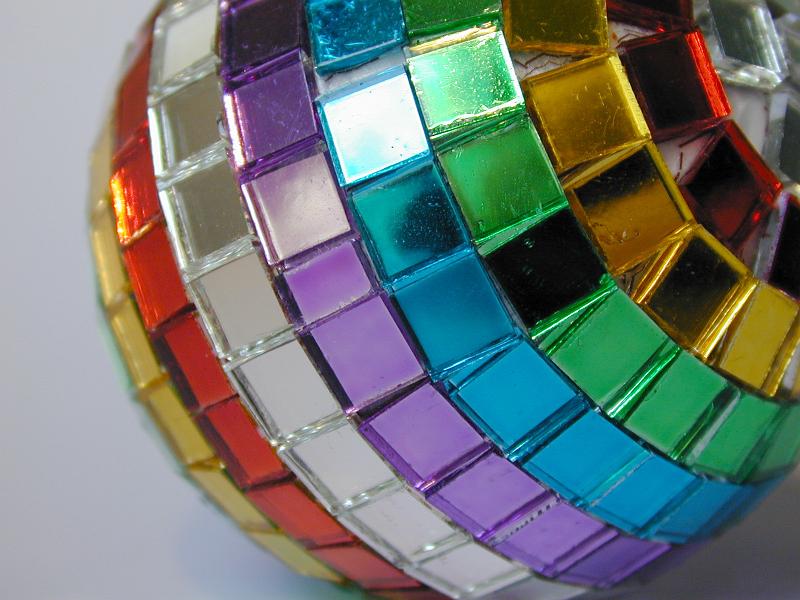 Free Stock Photo: Unusual vibrant multicolored festive bauble with rows of tiny mosaics in the colours of the rainbow, close up view for a colorful Christmas or holiday background
