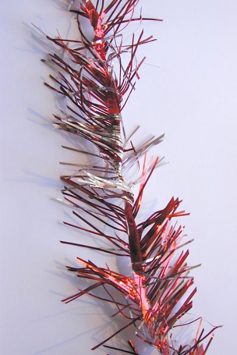 Free Stock Photo: Strand of festive red Christmas tinsel to decorate the tree or Xmas table lying on a grey background