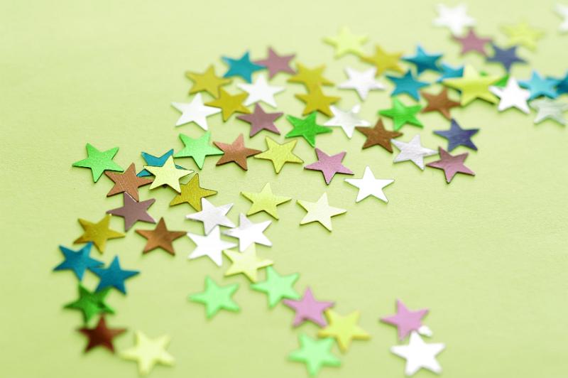 Free Stock Photo: Multi-Colored Star Shaped Stickers Scattered on Green Background, Full Frame for Backgrounds