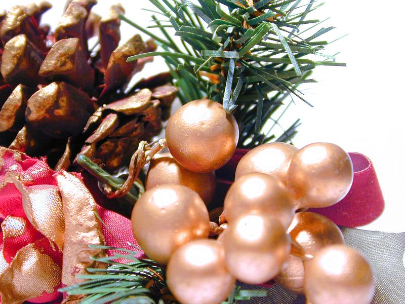 Free Stock Photo: Pine cone festive decoration with pearl beads and red ribbon with fake green foliage, close up background view for a Christmas or holiday concept