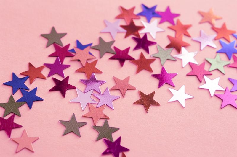 Free Stock Photo: Colorful Metallic Star Shaped Stickers Scattered on Pink Background