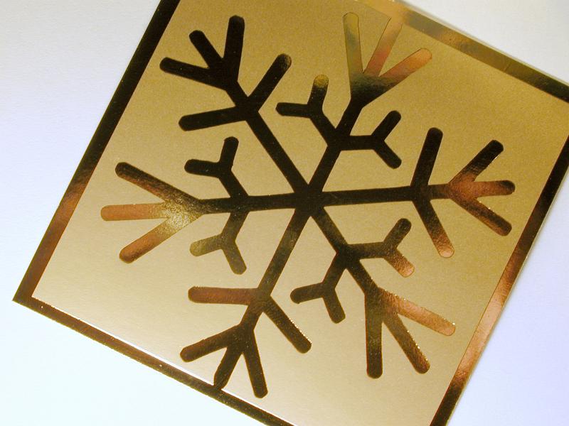 Free Stock Photo: Close up of shiny golden snowflake icon on square piece of paper on white background