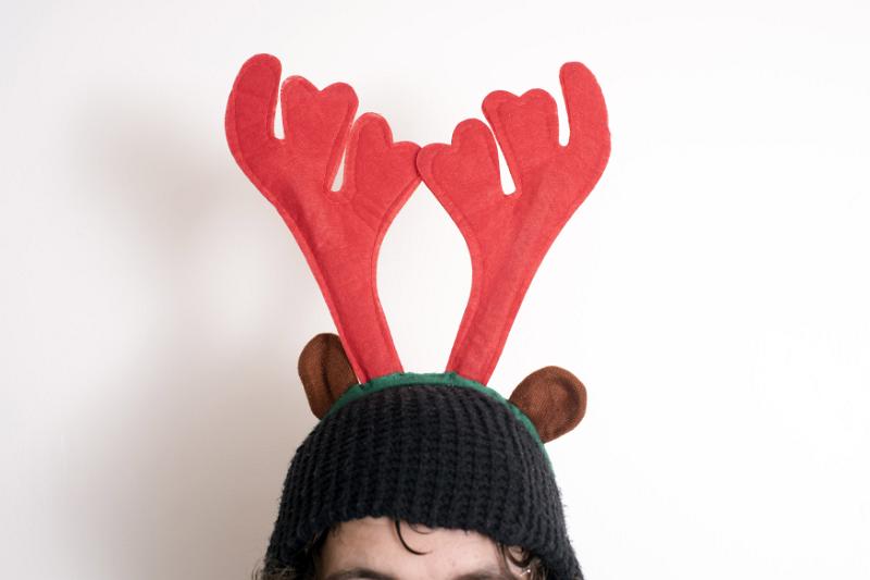 Free Stock Photo: Person wearing a decorative Reindeer hat with red antlers for Christmas in a close up cropped view on the hat