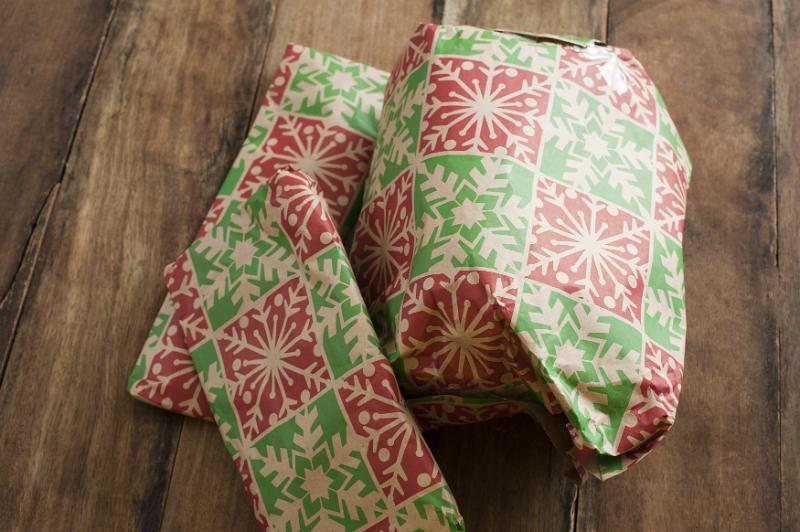 Free Stock Photo: Pile of colorful gift wrapped Christmas presents on a wooden floor in a close up high angle view