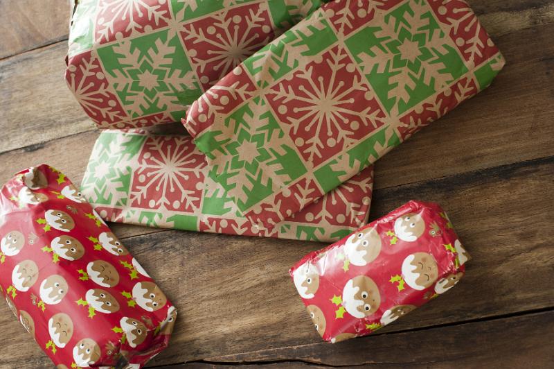 Free Stock Photo: Pile of brightly colored Christmas gifts in festive wrapping on a wooden floor viewed high angle