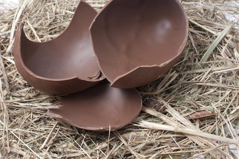 Free Stock Photo: Close-up of a chocolate Easter egg broken in pieces on fresh straw.