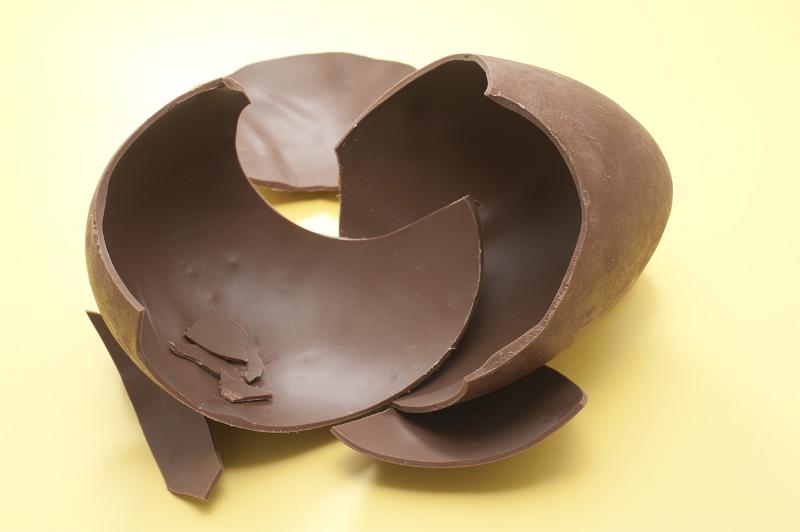 Free Stock Photo: Pieces of a chocolate Easter Egg photographed over yellow.