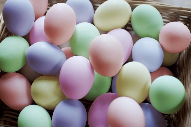 Free Stock Photo: A basket filled with colourful boiled and dyed hens eggs for Easter in pastel shades.