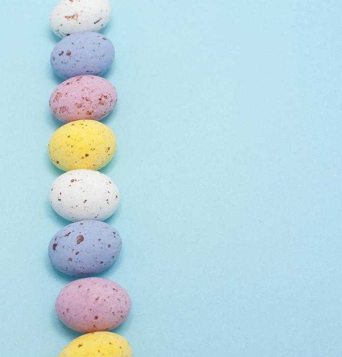 Free Stock Photo: Easter Egg Border. Line of speckled candy Easter eggs on a blue background with copyspace.
