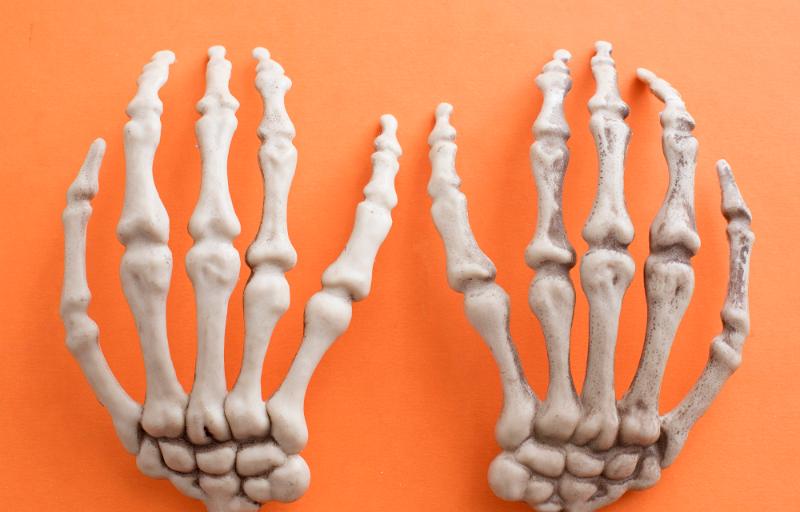 Free Stock Photo: a pair of spooky skeleton hands on an orange background