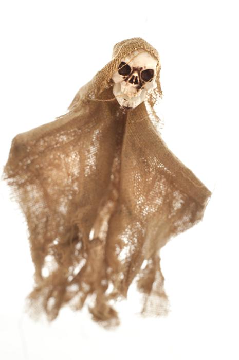 Free Stock Photo: Rustic scary homemade Halloween skull doll wrapped in frayed burlap or hessian over a white background