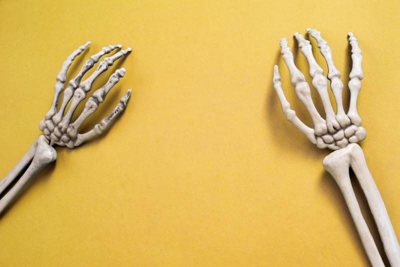 Free Stock Photo: a halloween background with two skeleton arms on yellow