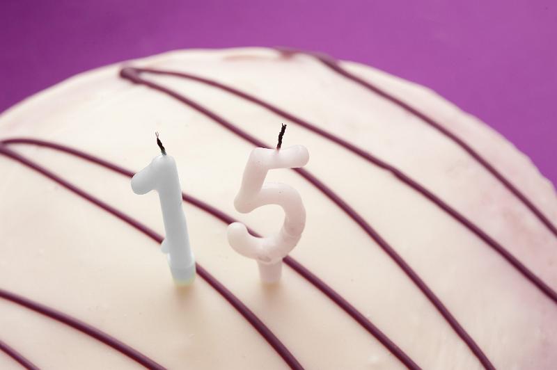 Free Stock Photo: White Cake Drizzled with Chocolate Icing Topped with Unlit Candles for 15th Birthday Celebration, Teenagers Birthday on Purple Background