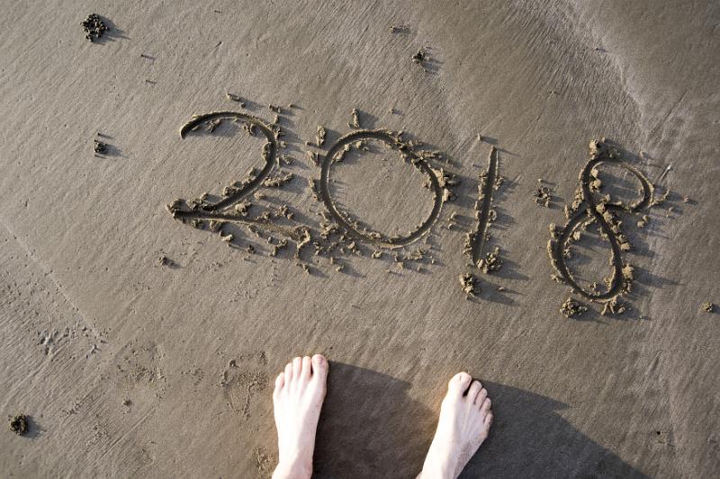 Free Stock Photo: Number of new year 2018 written with the stick on seashore sand, viewed from above with persons bare feet visible