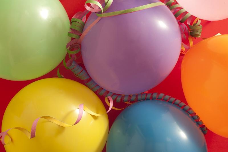 Free Stock Photo: Colourful festive background of multicoloured vibrant party balloons with streamers on a red background for a birthday, carnival or festive holiday celebration