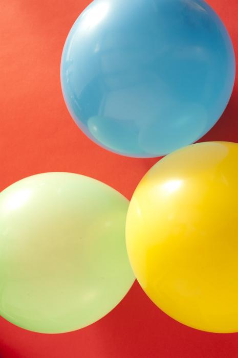 Free Stock Photo: High Angle View of Three Inflated Balloons on Red Background, in Yellow, Blue and Green Colors