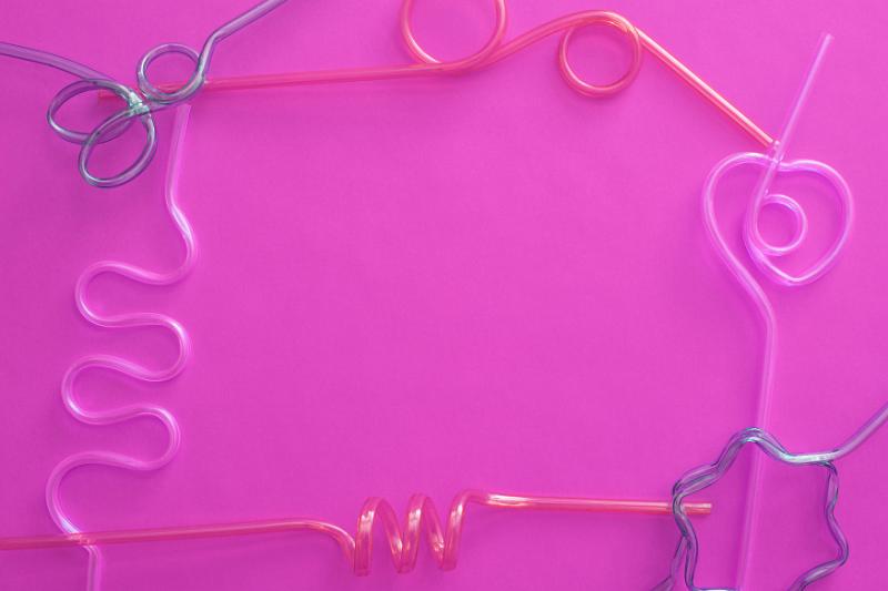 Free Stock Photo: Colorful psychedelic pink bendy straw border with assorted shapes around a central festive copy space for your greeting or party invitation