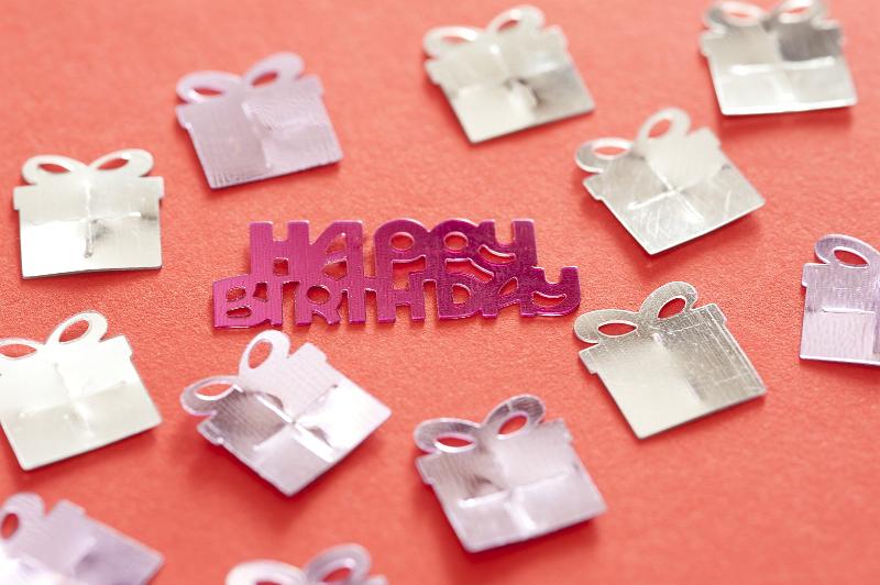Free Stock Photo: a background image with birthday decorative sprinkles arranged to show happy birthday surrounded by gifts