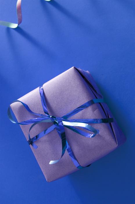 Free Stock Photo: Small Square Gift Box Wrapped in Silver Paper with Shiny Blue Ribbon Tied in Bow on Blue Background