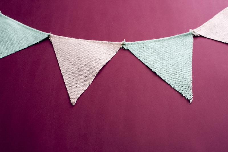 Free Stock Photo: Triangular pink and blue bunting on a red background forming an upper border with copy space below