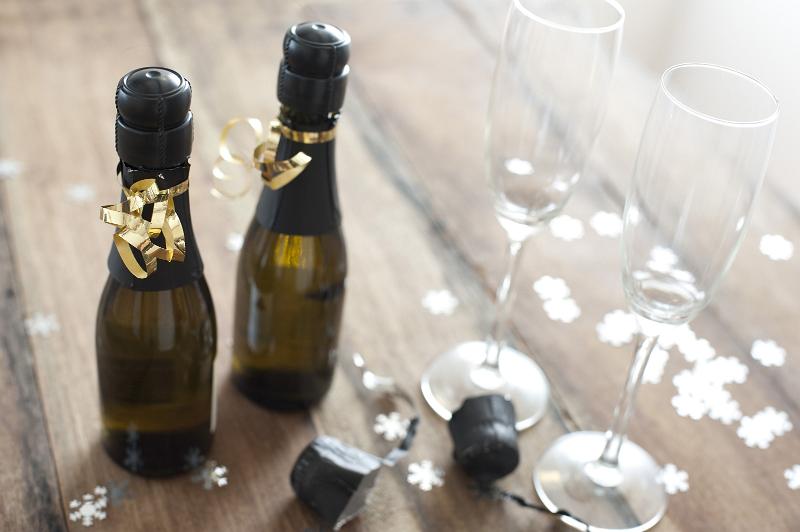 Free Stock Photo: Two Mini Bottles of Champagne Beside Champange Flute Glasses Surrounded by Confetti on Wooden Background, Celebration Themed Image for New Years or Christmas