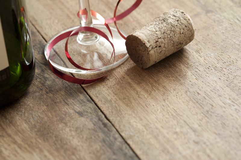 Free Stock Photo: Party champagne concept with a cork alongside a bottle and flute decorated with a festive red ribbon on a wooden table with copy space