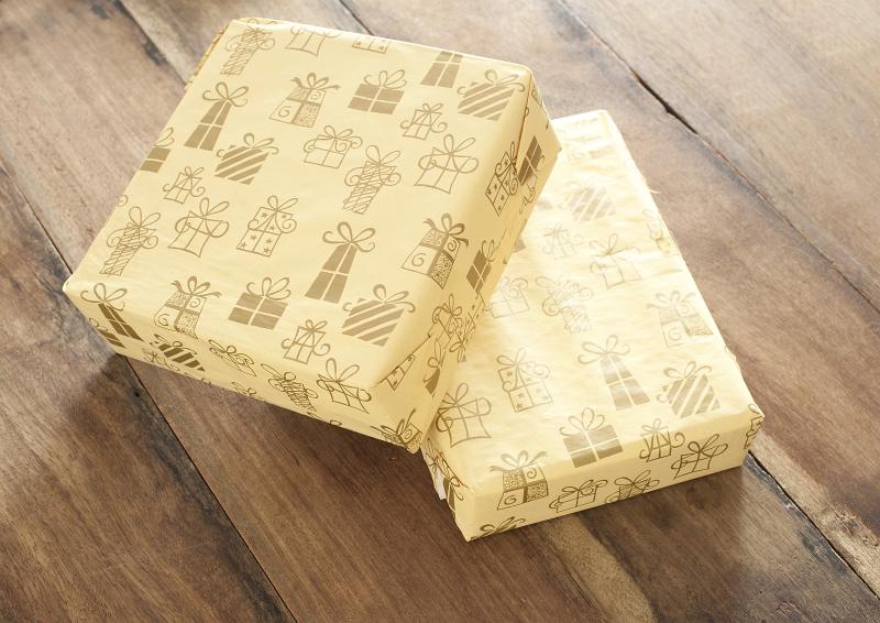 Free Stock Photo: Two Birthday Gifts Wrapped in Matching Patterned Yellow Paper Stacked on Wooden Surface