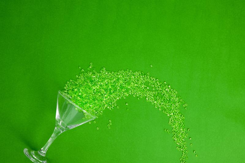 Free Stock Photo: Green party concept with spilled drink decoration of a martini glass lying on its side and copy space above
