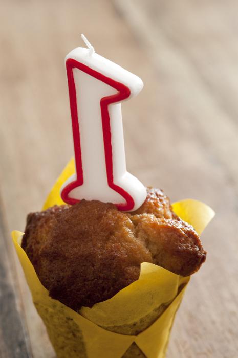 Free Stock Photo: Close Up of Number One Candle Inserted in Muffin or Individual Cake Wrapped in Yellow Paper for First Birthday