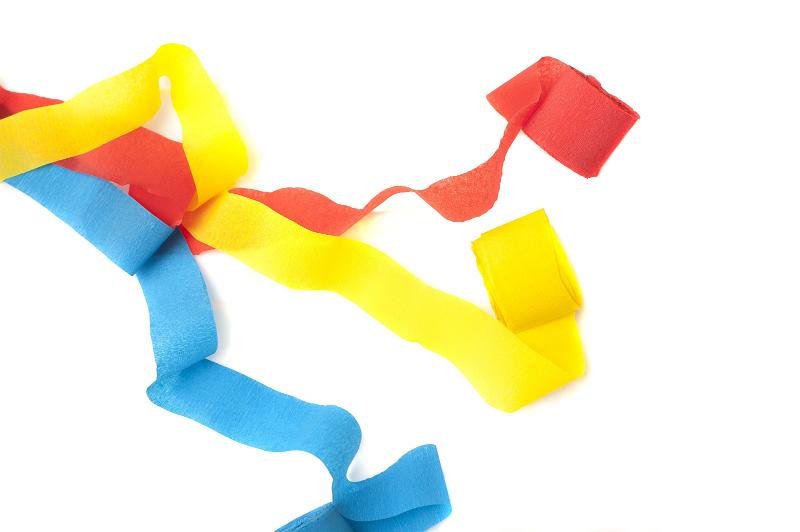 Free Stock Photo: Three vibrant colourful paper streamers in red, yellow and blue for a party, carnival or festive occasion on a white background