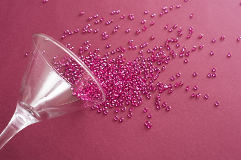 Free Stock Photo: Party decorations concept cocktail of beads spilled from martini glass over red surface background