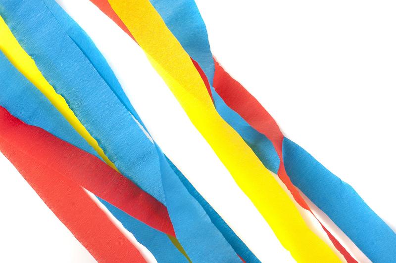 Free Stock Photo: Strands of Blue, Yellow and Red Decorative Paper Streamers Across White Background