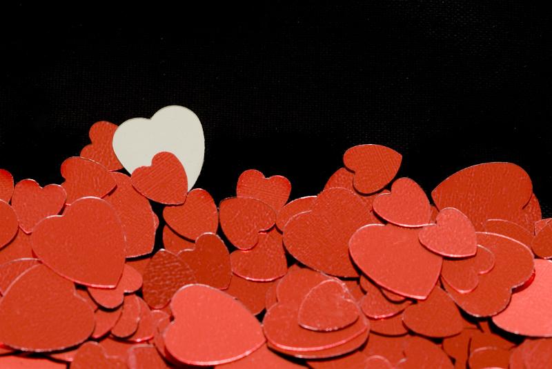 Free Stock Photo: a background or bottom border of red metallic heart shapes on a black backdrop